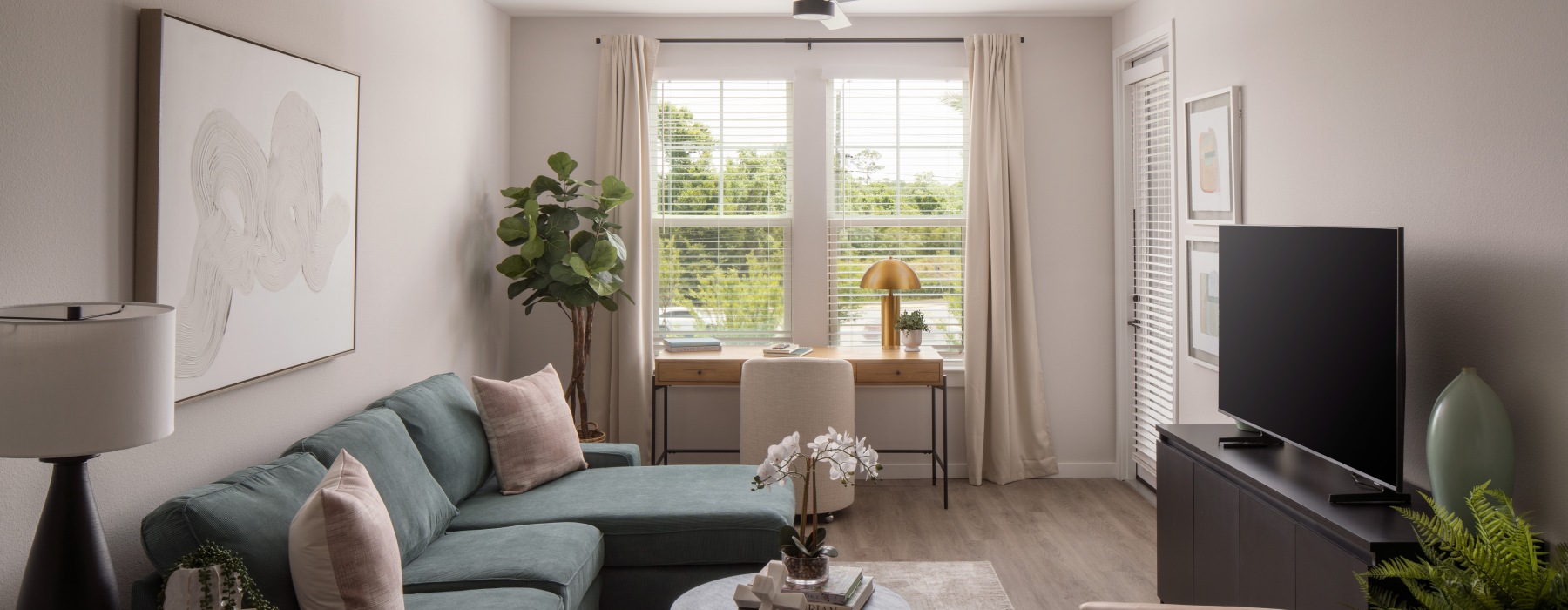 a living room with a green couch and a fan