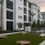a patch of grass with corn hole boards with a pool in the background
