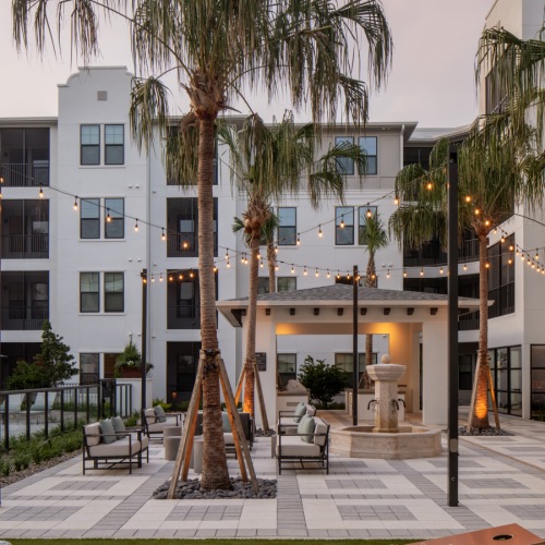 outdoor courtyard with a fountain and lawn games with a grilling pavilion 