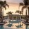 a pool at sunset with a pavilion in the background