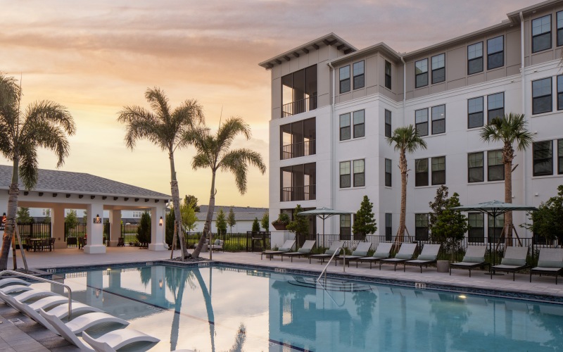 a pool with a building at sunset